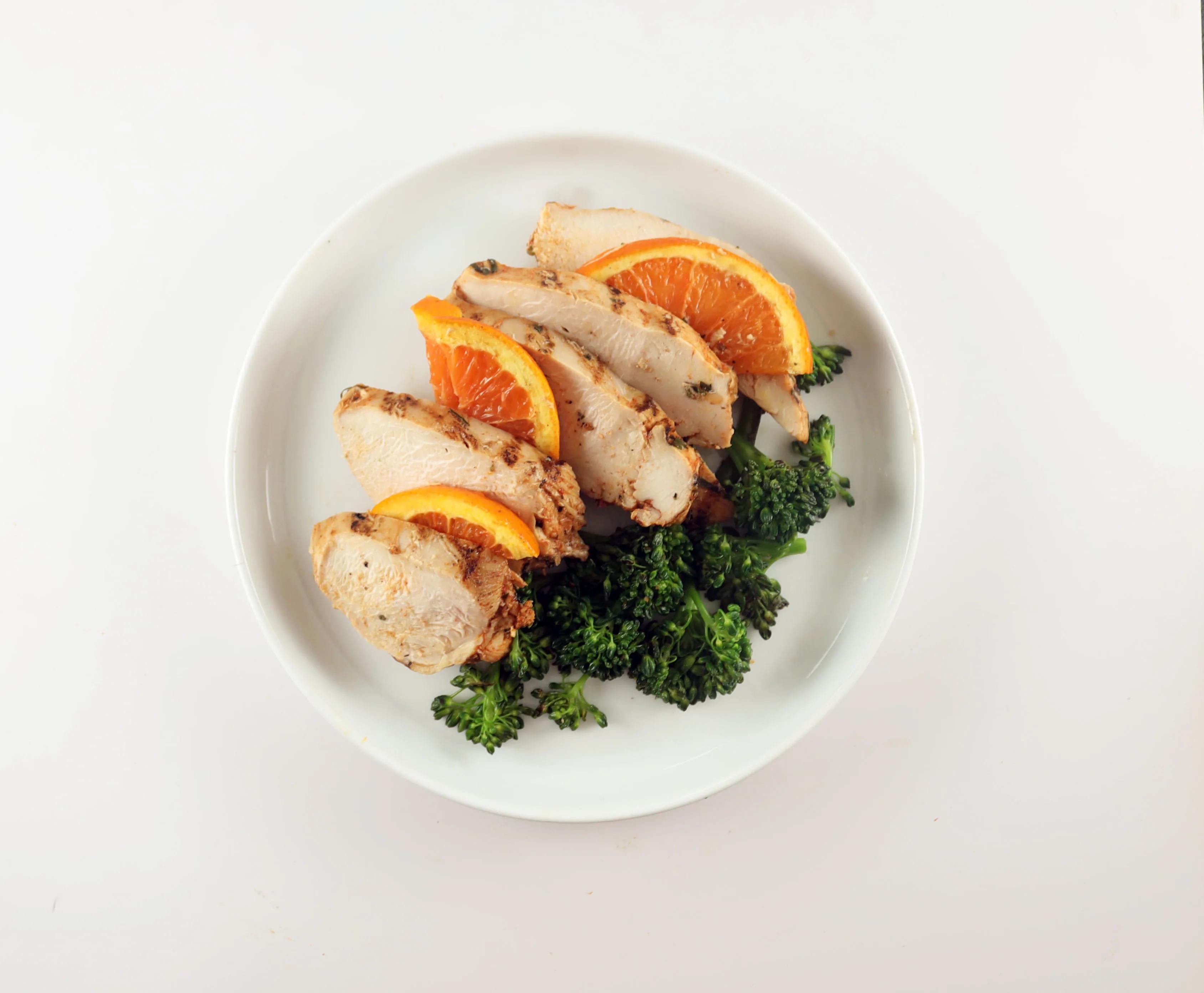 Citrus chicken with orange slices and broccolini